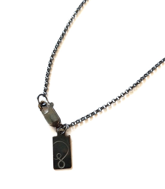 necklace clasp on white background with symbology tag by Alice Scott