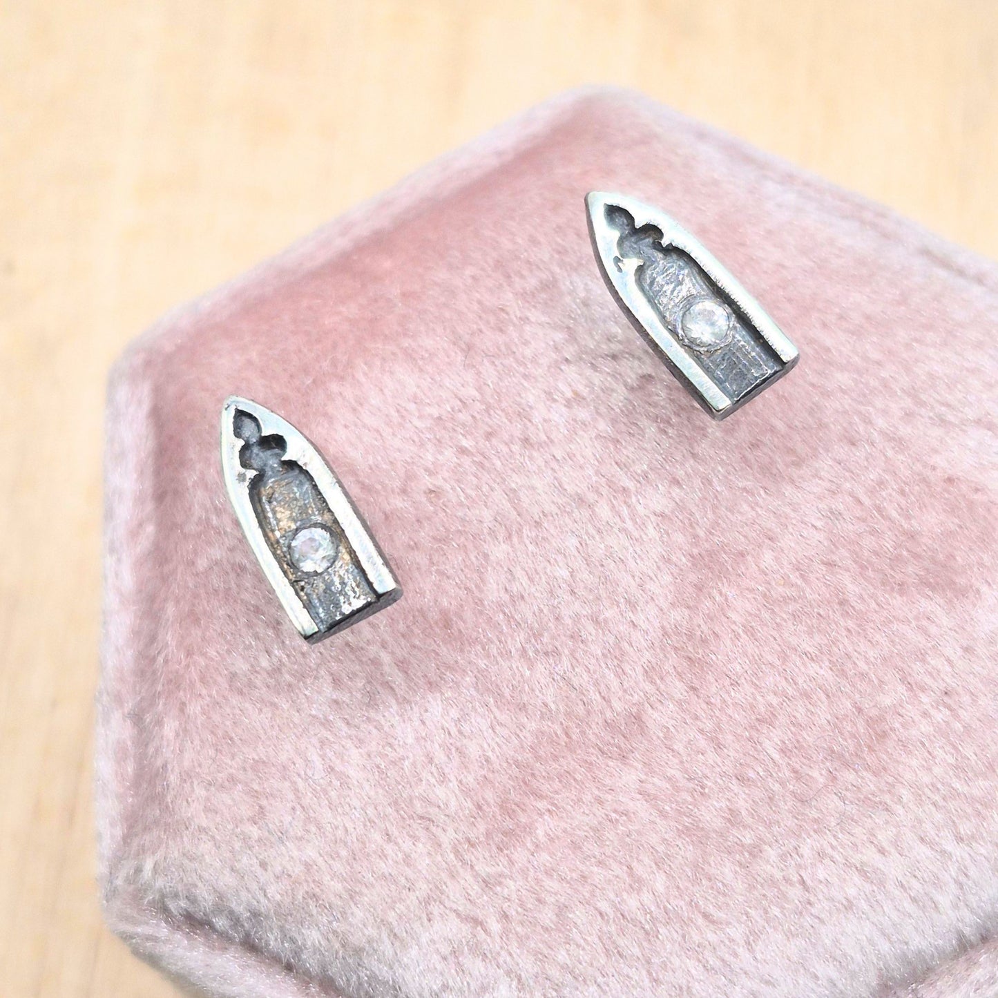 Silver gothic arch earrings with whit sapphire stones on a pink fabric background by Alice Scott