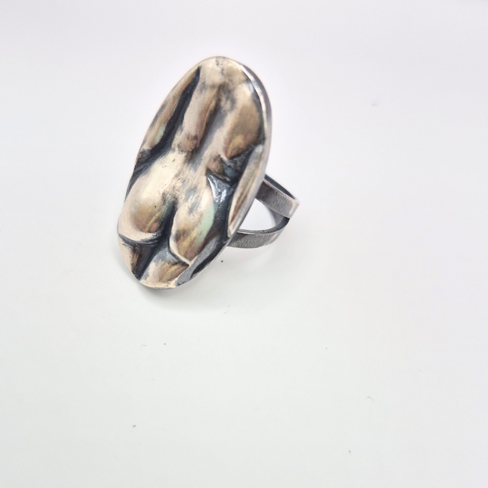 Silver ring with a unique woman body design on a white background by alice scott