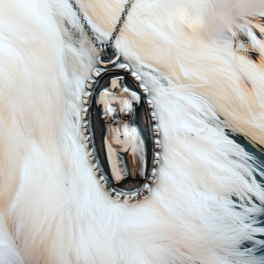 handmade Woman torso in sterling silver cameo pendant in sterling silver with black patina, on feather background, by Alice Scott