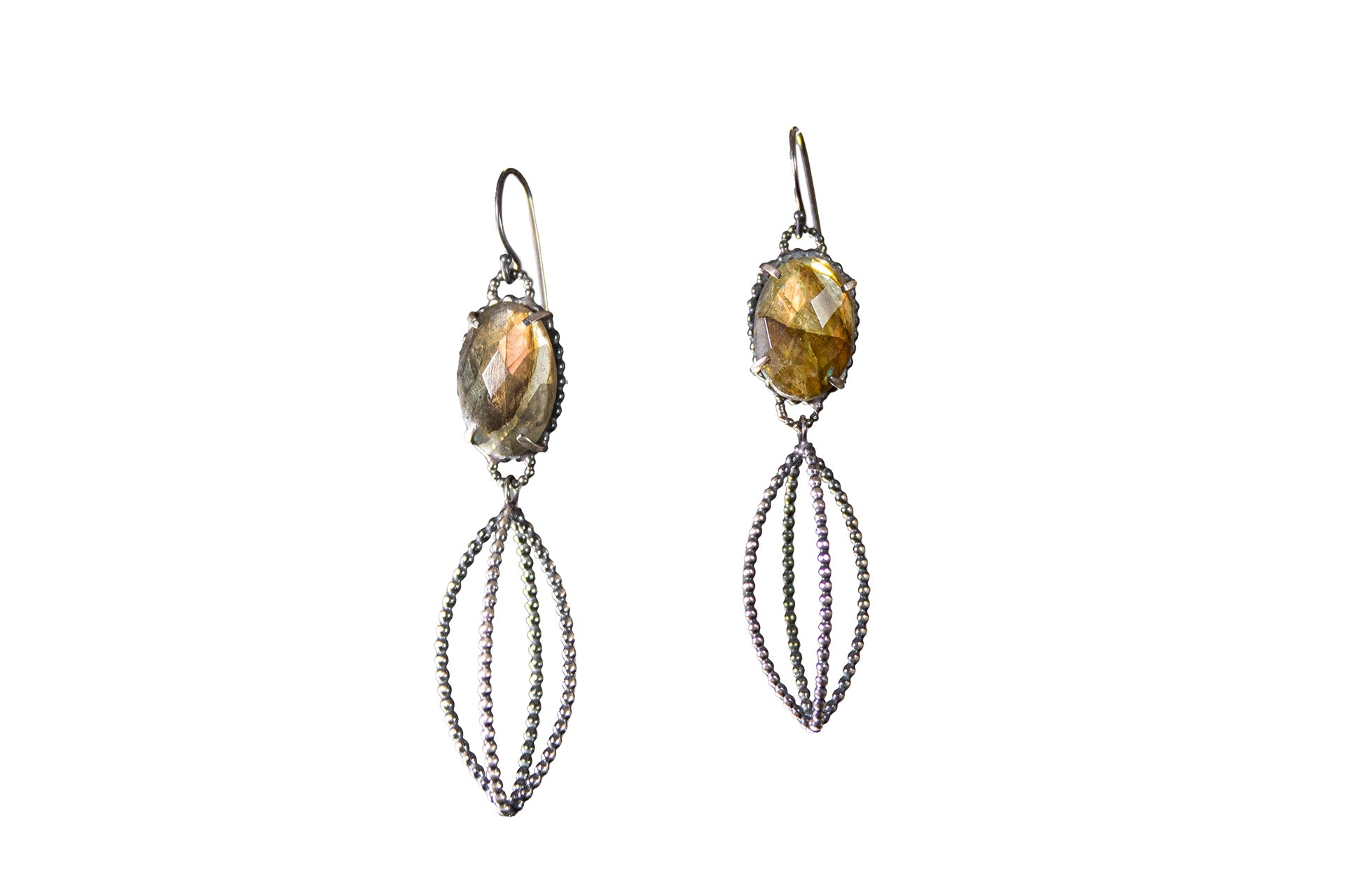 A pair of dangle earrings featuring natural labradorite stones with a silver dotted cage below captured against a white background by Alice Scott