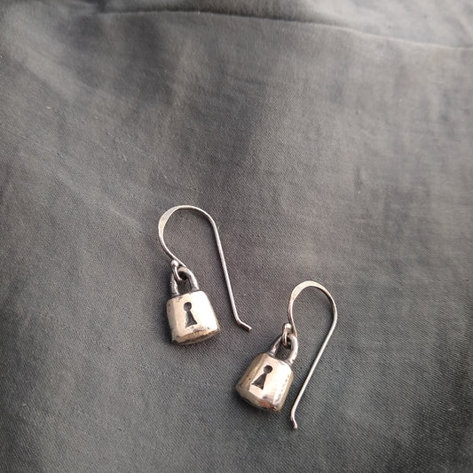 handmade padlock earrings in sterling silver with black patinas, on fabric background by Alice Scott