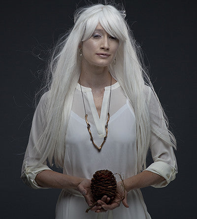 A necklace with bronze hand-shaped links connected by silver rings, with a blackened silver chain by Alice Scott on model with long white hair